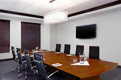a conference room with a large wooden table and chairs at Four Points by Sheraton Hotel & Suites Calgary West in Calgary