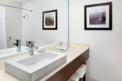 a white bathroom with a large white sink at Four Points by Sheraton Hotel & Suites Calgary West in Calgary