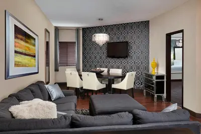 a living room with a couch and a dining room at Four Points by Sheraton Hotel & Suites Calgary West in Calgary