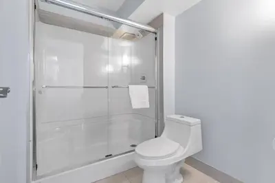 a bathroom with a shower and a toilet at Emerald Hotel & Suites Calgary Airport in Calgary
