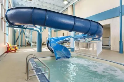 a blue water slide in a indoor swimming pool at Travelodge by Wyndham Edmonton West in Edmonton