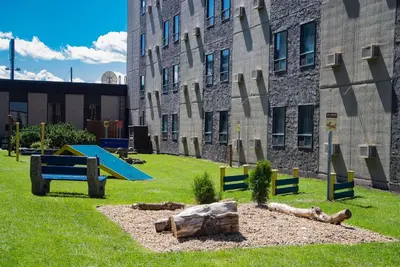 a playground in front of a building with a bench at Travelodge by Wyndham Edmonton West in Edmonton