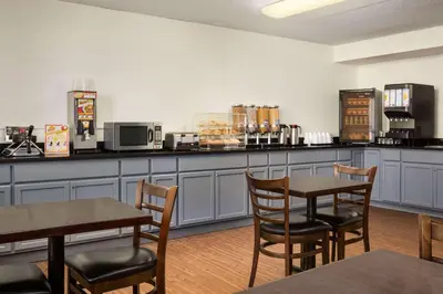 a restaurant with two tables and chairs and a counter at Travelodge by Wyndham Edmonton West in Edmonton