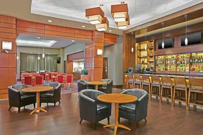 a restaurant with tables and chairs and a bar at Grand Park Hotel Vancouver Airport, an Ascend Collection Hotel in Richmond