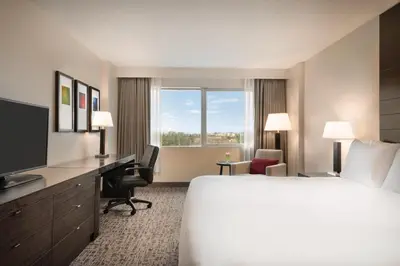 a hotel room with a bed and a desk and a television at Radisson Hotel Vancouver Airport in Richmond