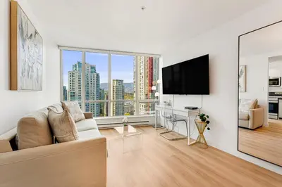 a living room with a couch and a flat screen tv at Best Location Downtown Chic Suites in Vancouver