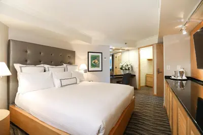 a hotel room with a large bed and a kitchen at Pan Pacific Vancouver in Vancouver