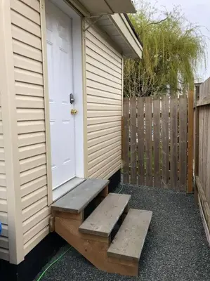 a porch with two steps next to a door at Shady Willow Guest House - SMALL Indipendent Units with Seperate Entrance for Travellers in Chilliwack