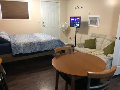 a room with a bed and a table and a bed and a couch at Shady Willow Guest House - SMALL Indipendent Units with Seperate Entrance for Travellers in Chilliwack