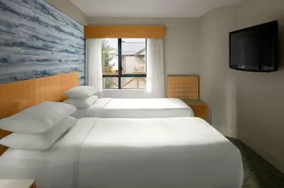 a hotel room with two beds and a television at Delta Hotels by Marriott Whistler Village Suites in Whistler