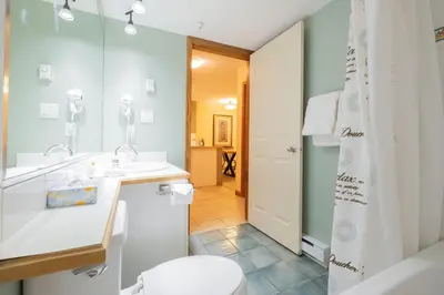 a bathroom with a white sink and a toilet at The Aspens by Outpost Whistler in Whistler