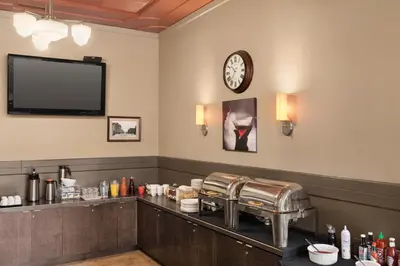 a waiting room with a counter with a clock on the wall at The Plaza Hotel Downtown, Trademark Collection by Wyndham in Kamloops