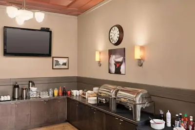 a waiting room with a counter with a clock on the wall at The Plaza Hotel Downtown, Trademark Collection by Wyndham in Kamloops