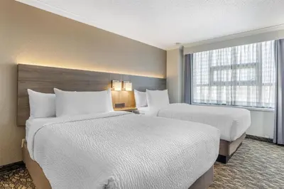 a hotel room with two beds and a window at BEST WESTERN PLUS Carlton Plaza Hotel in Victoria
