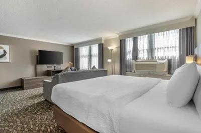 a hotel room with a large bed and a couch at BEST WESTERN PLUS Carlton Plaza Hotel in Victoria
