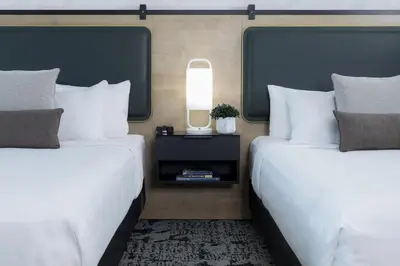 two beds in a hotel room with white pillows at The Crystal Lodge in Whistler