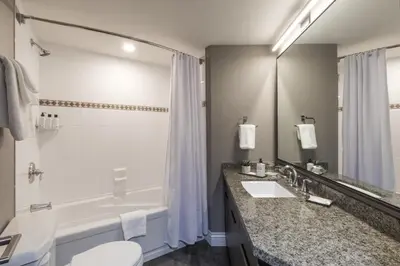 a bathroom with a tub and a toilet and a sink at The Crystal Lodge in Whistler