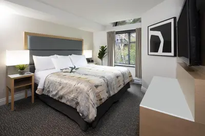 a hotel room with a bed and a window at The Crystal Lodge in Whistler