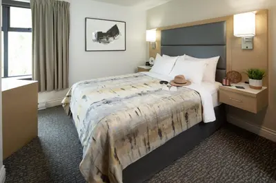 a hotel room with a bed with a hat on it at The Crystal Lodge in Whistler