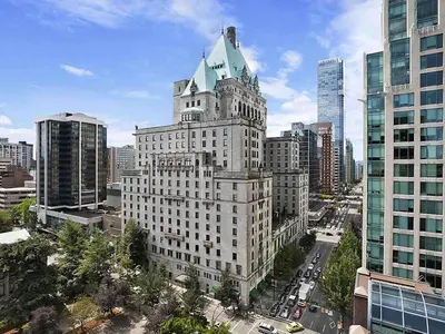a large white building in a city with tall buildings at Fairmont Hotel Vancouver in Vancouver