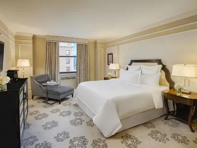 a bedroom with a large white bed and a chair at Fairmont Hotel Vancouver in Vancouver