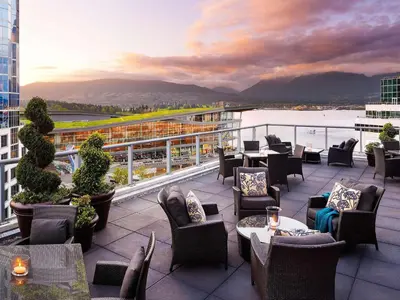 a balcony of a hotel with tables and chairs at Fairmont Waterfront in Vancouver