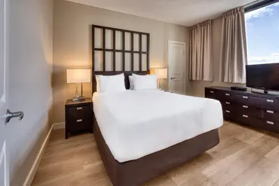a bedroom with a large bed and a flat screen tv at Oswego Hotel in Victoria