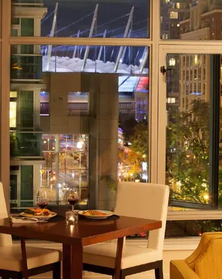 a dining room table with a view of a city at L'Hermitage Hotel in Vancouver