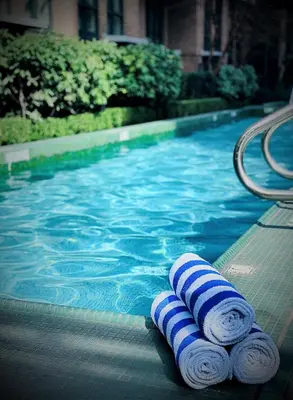 a swimming pool with two rolled up towels next to it at L'Hermitage Hotel in Vancouver