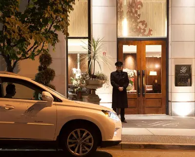 a man standing in front of a building at L'Hermitage Hotel in Vancouver