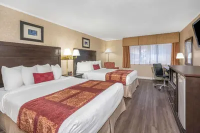 a hotel room with two beds and a television at Ramada by Wyndham Coquitlam in Coquitlam