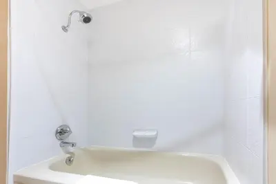 a white bathroom with a tub and a sink at Ramada by Wyndham Coquitlam in Coquitlam
