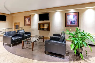 a waiting room with couches and a glass table at Ramada by Wyndham Coquitlam in Coquitlam