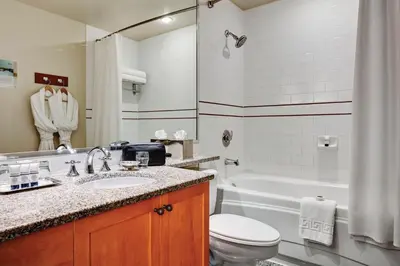 a bathroom with a sink and a toilet and a tub at Pan Pacific Whistler Mountainside in Whistler