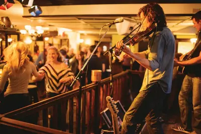 a man singing into a microphone in a crowd of people at Pan Pacific Whistler Mountainside in Whistler