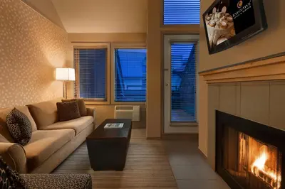 a living room with a couch and a fireplace at Executive Inn Whistler in Whistler