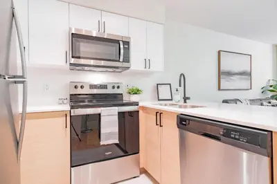 a kitchen with a stove and a microwave at Wildwood Lodge by Outpost Whistler in Whistler