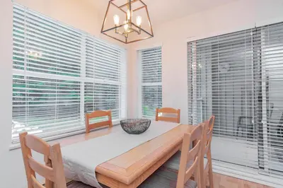 a dining room with a table and chairs and windows at Wildwood Lodge by Outpost Whistler in Whistler