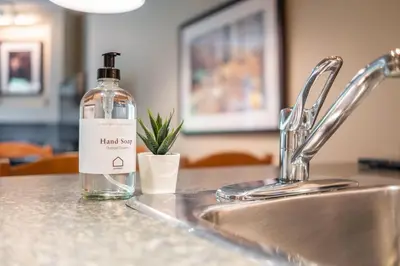 a bottle of alcohol sitting on top of a sink at Wildwood Lodge by Outpost Whistler in Whistler