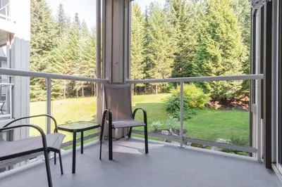 a room with a large window with chairs and a table at Wildwood Lodge by Outpost Whistler in Whistler