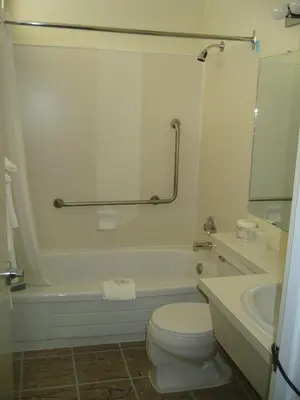 a bathroom with a toilet and a tub and a sink at Hospitality Inn in Kamloops
