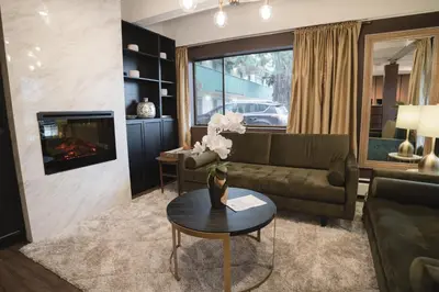 a living room with a couch and a table at Robin Hood Inn and Suites in Victoria