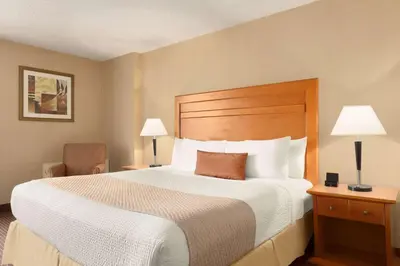 a hotel room with a large bed and two lamps at Days Inn by Wyndham Edmonton Downtown in Edmonton