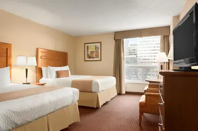 a hotel room with two beds and a flat screen tv at Days Inn by Wyndham Edmonton Downtown in Edmonton