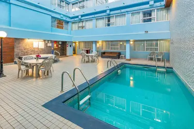 a pool in a hotel with a table and chairs at Comfort Inn & Suites in Edmonton