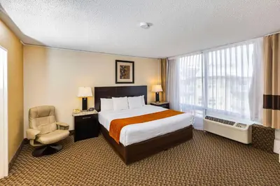a hotel room with a bed and a chair at Comfort Inn & Suites in Edmonton