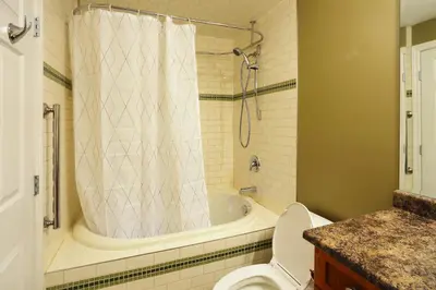 a bathroom with a tub and a toilet and a shower at Lovely J Home -Stunning river view cozy two bedroom private suite in New Westminster