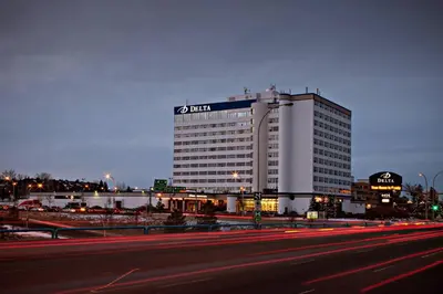 a large white building with a sign on top of it at Delta Hotels by Marriott Edmonton South Conference Centre in Edmonton