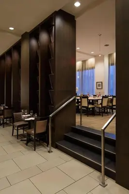 a dining room with tables and chairs and a staircase at Delta Hotels by Marriott Edmonton South Conference Centre in Edmonton