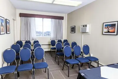 a conference room with blue chairs and a window at Campus Tower Suite Hotel in Edmonton